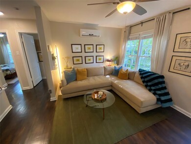 Living room featuring a ceiling fan, dark wood-ty
