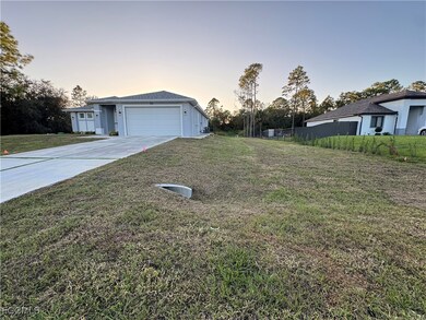 View of front of home with driveway, a front lawn, and a garage