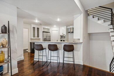 Kitchen featuring kitchen peninsula, light stone c
