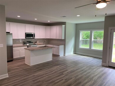 Kitchen with white cabinets, sink, appliances with