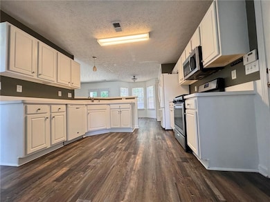 Kitchen featuring white cabinets, dark wood-style 