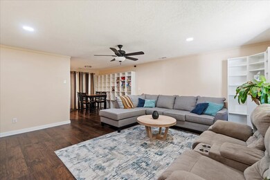 Living room featuring wood finished floors, ornamental molding, a ceiling fan, recessed lighting, and a textured ceiling
