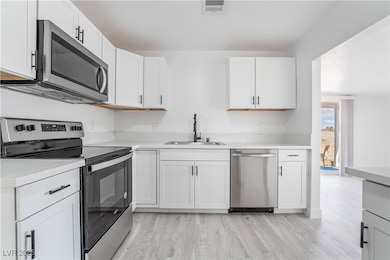Kitchen with a sink, visible vents, appliances wit