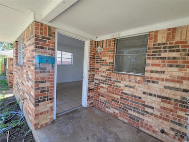 View of exterior entry featuring covered porch and