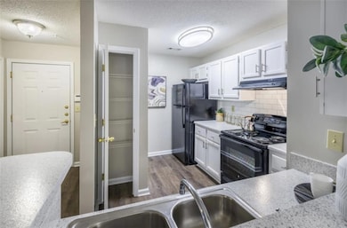 Kitchen featuring black appliances, backsplash, wh