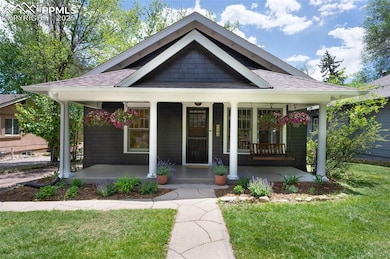 View of front of home featuring a porch, roof with shingles, and a front yard