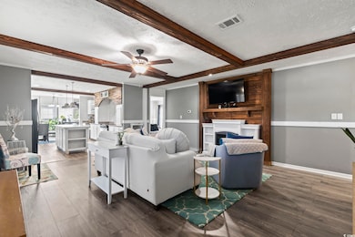 Living area with a textured ceiling, visible vents
