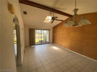 Empty room featuring a textured ceiling, lofted ce