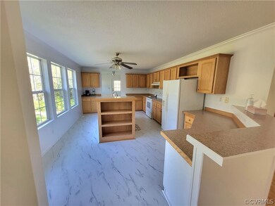Kitchen with kitchen peninsula, a kitchen island, white appliances, ceiling fan, and sink