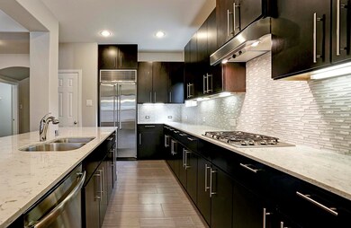 The built in refrigerator, sleek cabinets, fabulous backsplash, and stunning counters add tremendous  “WOW” factor to this chef’s kitchen.