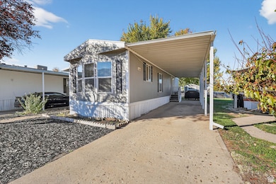 View of side of property featuring a carport and driveway