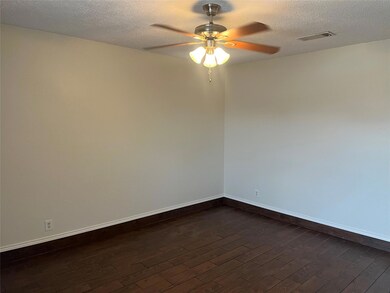 Bedroom with a textured ceiling, visible vents, ba