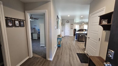 Corridor with wood finished floors and recessed lighting