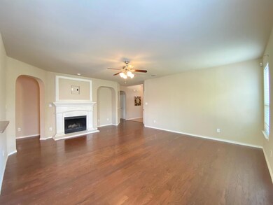 Unfurnished living room with ceiling fan and dark hardwood / wood-style flooring