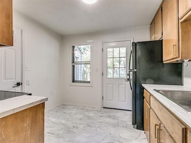 Kitchen featuring freestanding refrigerator, marbl