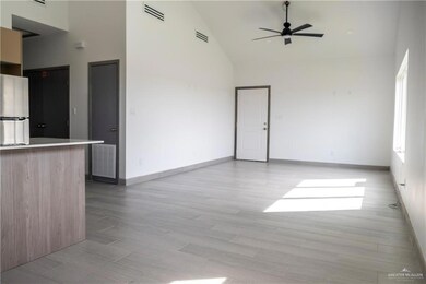 Unfurnished living room featuring light hardwood / wood-style floors, high vaulted ceiling, and ceiling fan