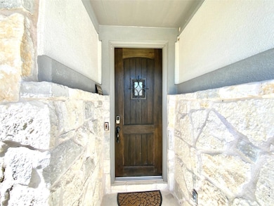 Property entrance featuring stone siding and stucco siding