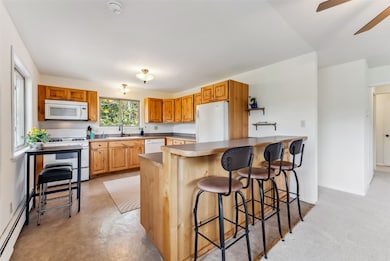 Kitchen featuring white appliances, baseboard heat