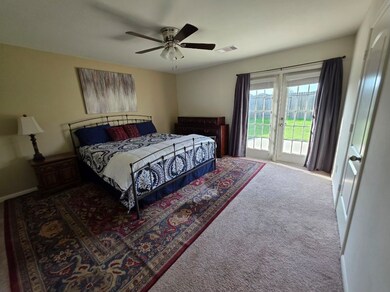 Primary Bedroom with french doors leading out to p