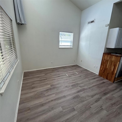 Unfurnished room with baseboards, dark wood-style