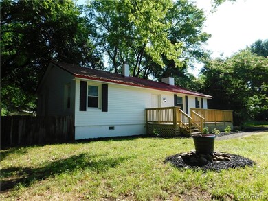 Rear view of property featuring a deck and a lawn