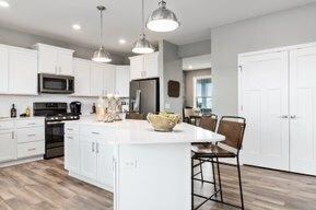 This large kitchen with walk-in pantry features slate appliances, spacious center island, quartz countertops and notice the abundance of cabinet and counter space!! Photos are of a decorated model home and finishes will vary.