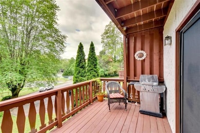 Wooden deck with grilling area and view of wooded area