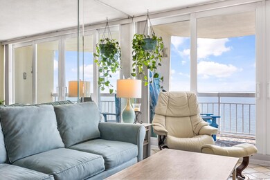 Living room with a wall of windows, a water view, 