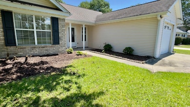View of front of property with a shingled roof, an attached garage, a front yard, and concrete driveway