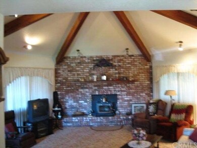 Living Room Accented With Beams & Cozy Fireplace