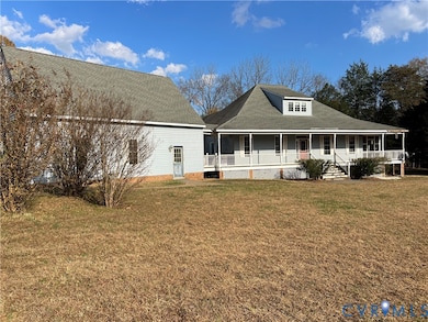 Front of house featuring covered porch, a lawn, and a shingled roof