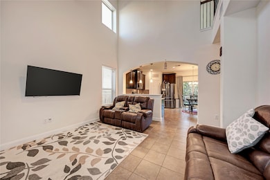 Living area with arched walkways, light tile patt