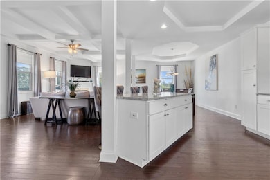 Kitchen with dark wood finished floors, light ston