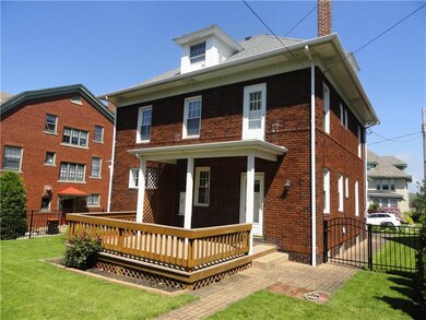 Fenced in yard with brick sidewalks.