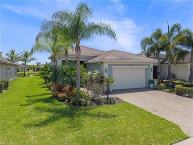 View of front of house with a front yard, stucco siding, a garage, decorative driveway, and a tiled roof