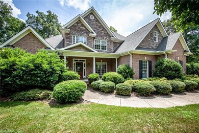 Beautiful landscaping, covered front porch, brick and stone facade- the ultimate curb-appeal triple threat