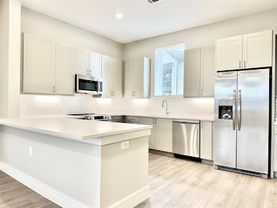 Kitchen featuring backsplash, appliances with stai