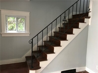 Wrought iron railing wood staircase.