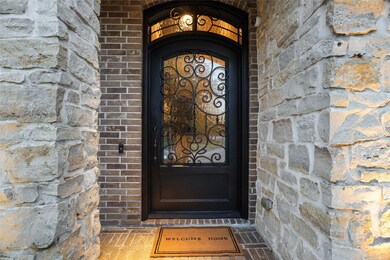Beautifully-crafted stone and iron entrance! Custom oversized front door.