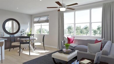 Living room featuring a ceiling fan, light wood f