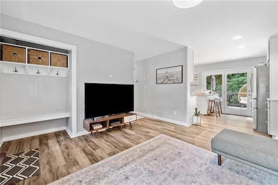 Living area with tons of natural light, wood-style floors, recessed lighting, and entrance mudroom.