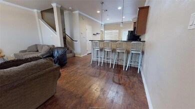 Kitchen with fridge, a breakfast bar area, dark wo