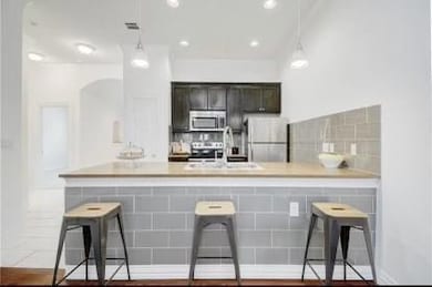 Kitchen featuring light countertops, stainless st
