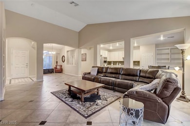 Living area with arched walkways, light tile patte