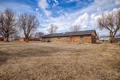 Rear view of house featuring brick siding, fence, 