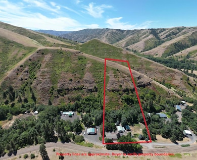 Aerial view of property's location featuring a mountainous background and property parcel outlined