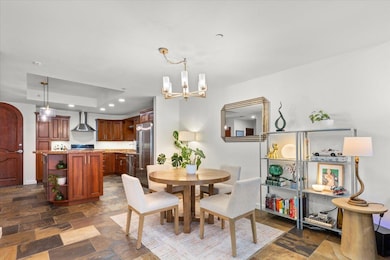 Dining room featuring stone finish flooring, recessed lighting, and a notable chandelier