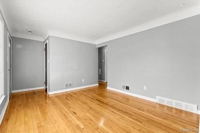 Spare room featuring light wood finished floors and baseboards