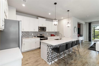 Stainless steel appliances, upgraded light fixtures, tiled backsplash and kitchen island all add to this home's beauty!