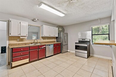 Kitchen with sink, white cabinets, light tile floo
